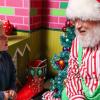 Santa listening to a child at Kringle's Inventionasium experience, an immersive attraction in Seattle for families during Christmas