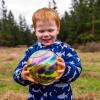 young child holding a glass float found during Northwest Glass Quest, a glass float hunt on Camano Island