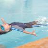 Boy floating in the water on his back in a swimming lesson