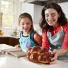 child and mom making challah together