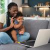 mom holding a baby waving to a computer call finding community online