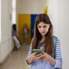 a student looks at a cell phone at school and seems unhappy