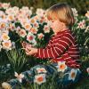 child sitting in a field of flowers