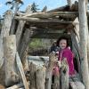 young girl in a driftwood fort on Deception Pass State Park beach, with a nearby campground for families