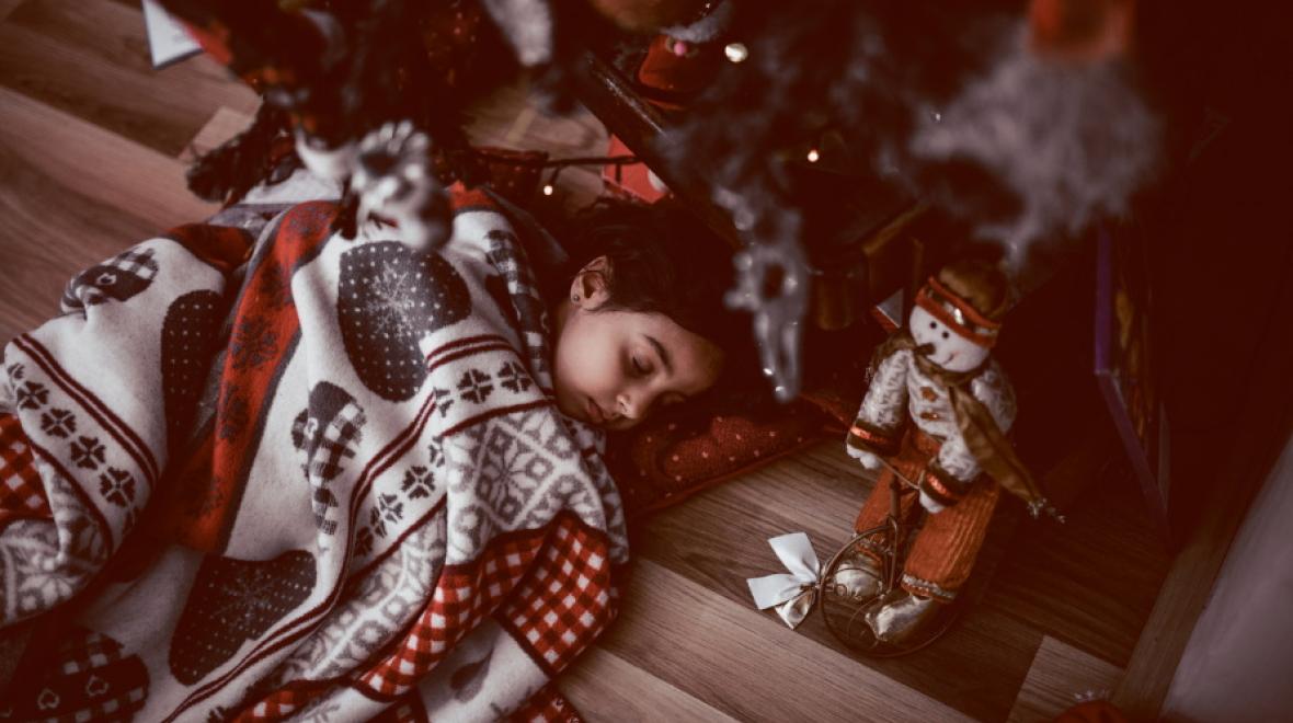 kid-sleeping-at-Christmas-tree