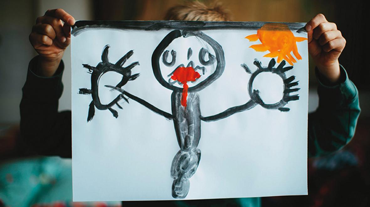 kid holding up a drawing of a black figure with red lips and a yellow sun in the background