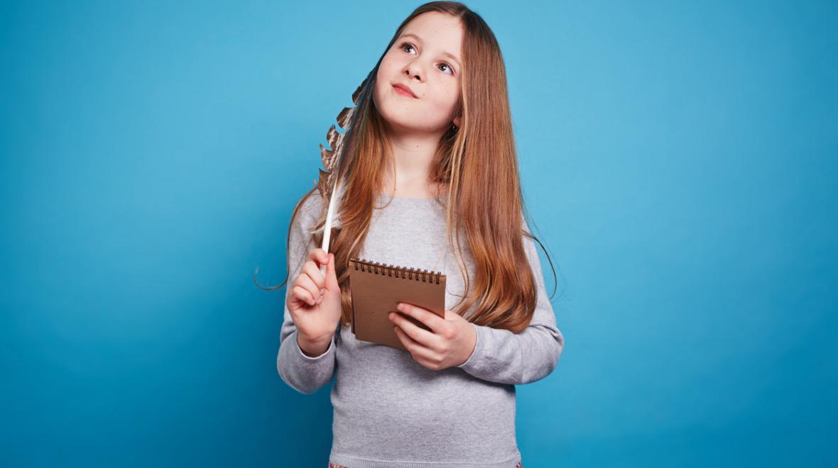 Young girl holding a notebook and thinking about what she is going to write about