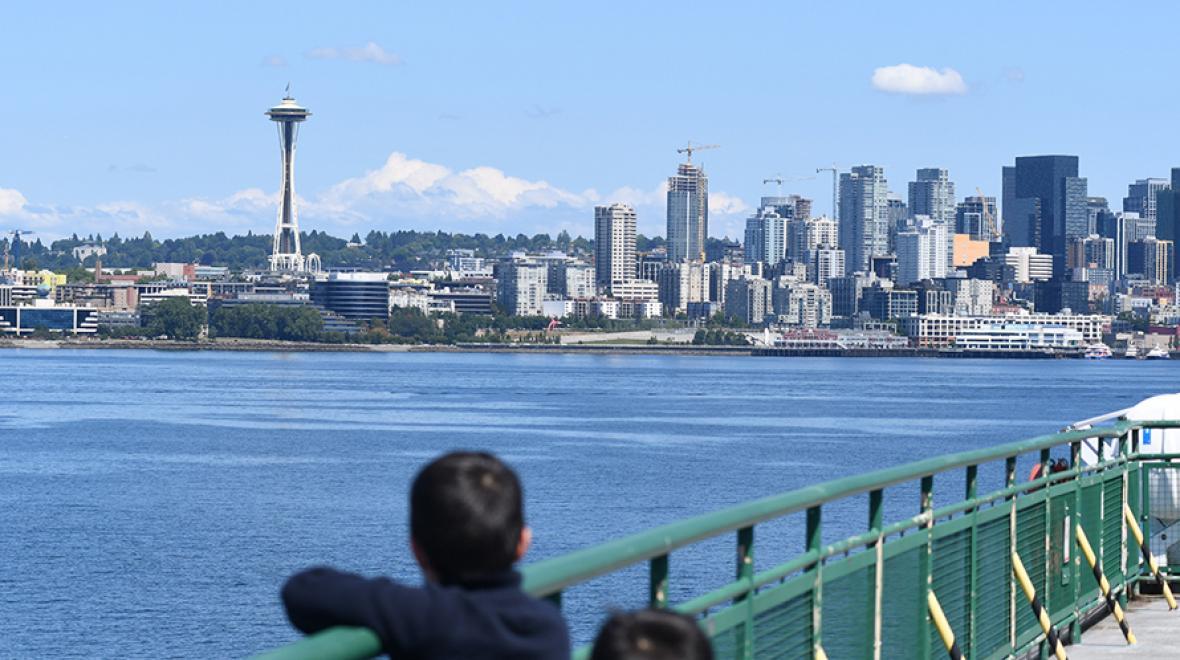 kids on the bainbridge ferry looking back at seattle