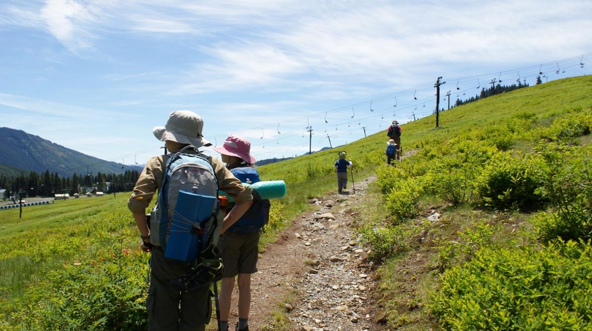 Kids with backpacks hike along the Lodge Lake trail among great wildflower hikes