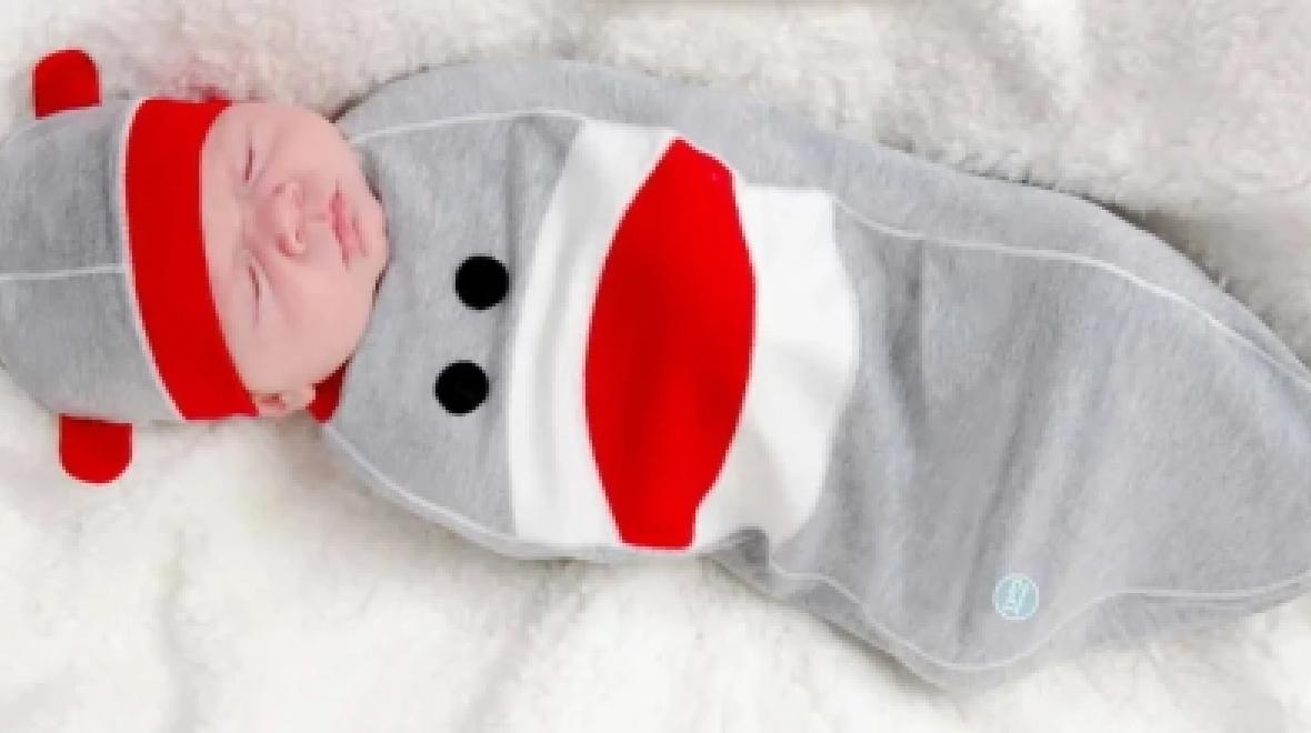 Baby wearing a sock monkey costume