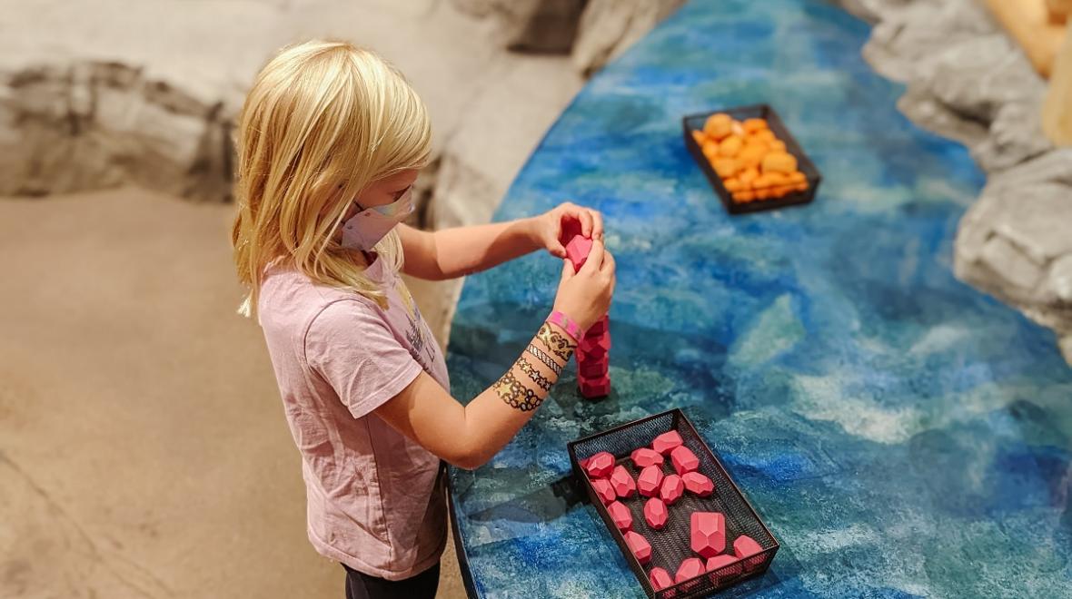 A girl plays with gems at an interactive exhibit station at Imagine Children's Museum in Everett, near Seattle, among sensory-friendly destinations for families with kids on the spectrum or with sensory needs