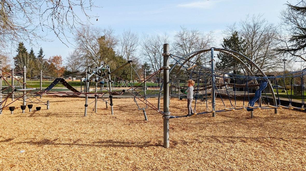 A young boy climbs on the extensive network of rope climber elements at the adventurous Seattle playground at Rainier Beach Playfield in South Seattle