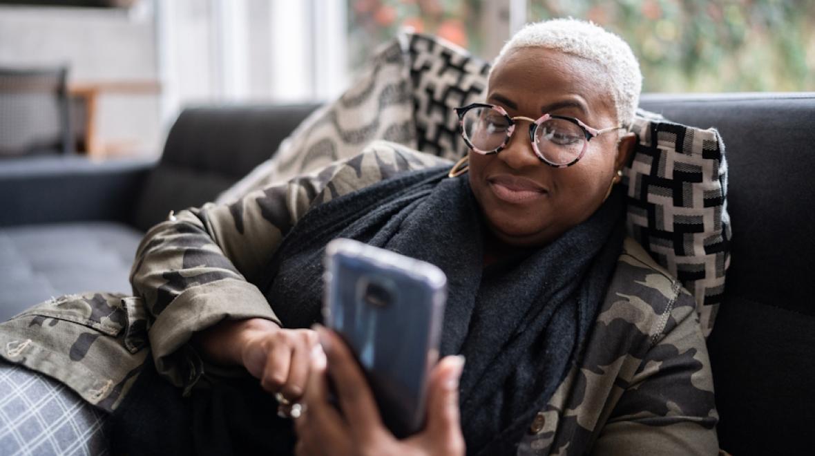 Woman watching a TikTok parenting tip video on the couch 