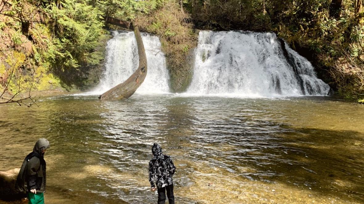 Kids stand in front of Cherry Creek, a Seattle waterfall in Duvall