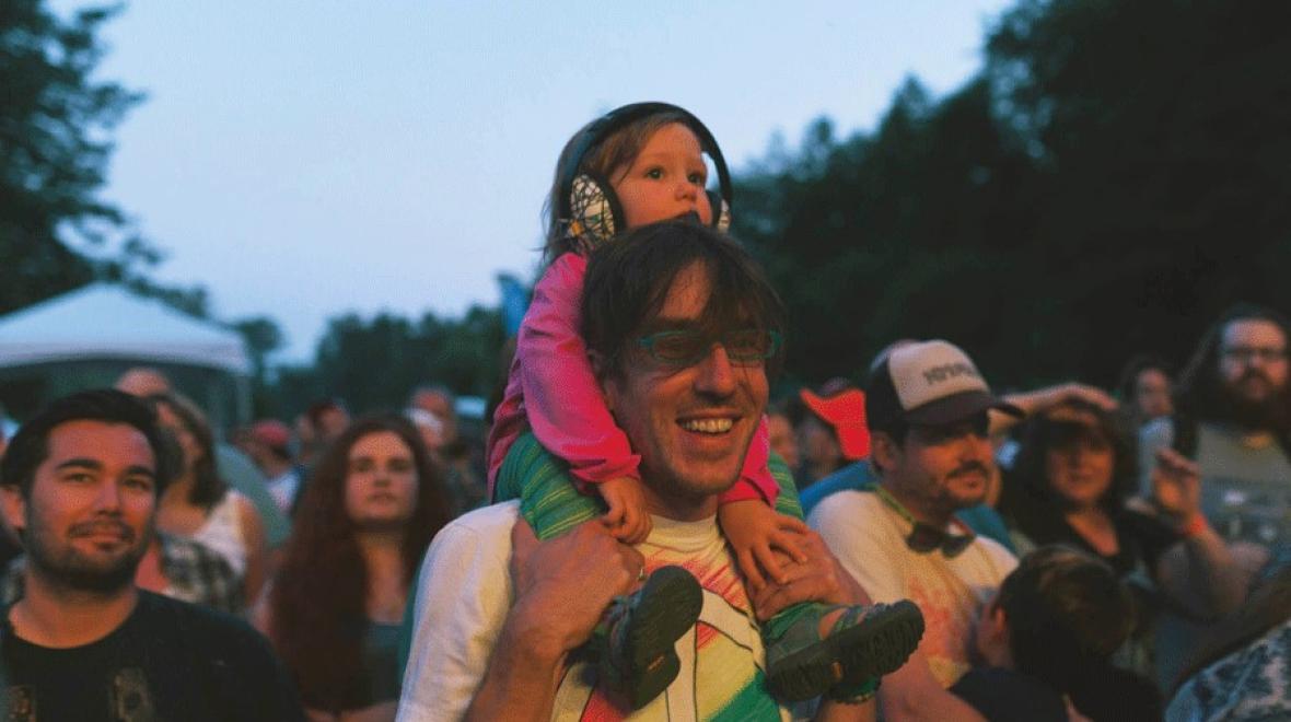 Young child on dad's shoulders enjoying iconic Seattle music festival Timber