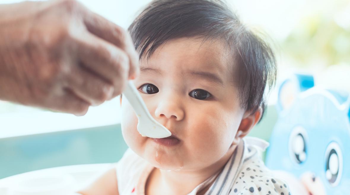 Baby eating food that came in a baby subscription box