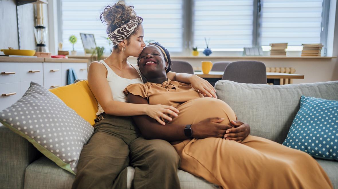 Pregnant mom sitting with her partner on a couch