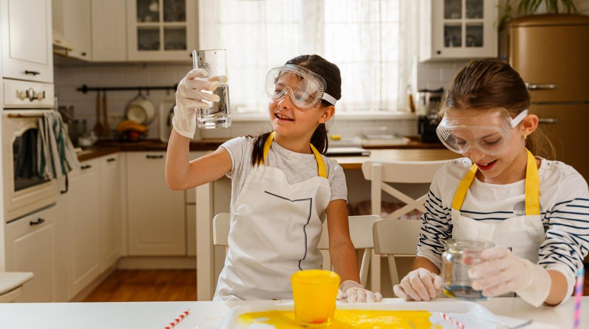 Two kids doing science experiments in their kitchen and enjoying inside summer activities for kids