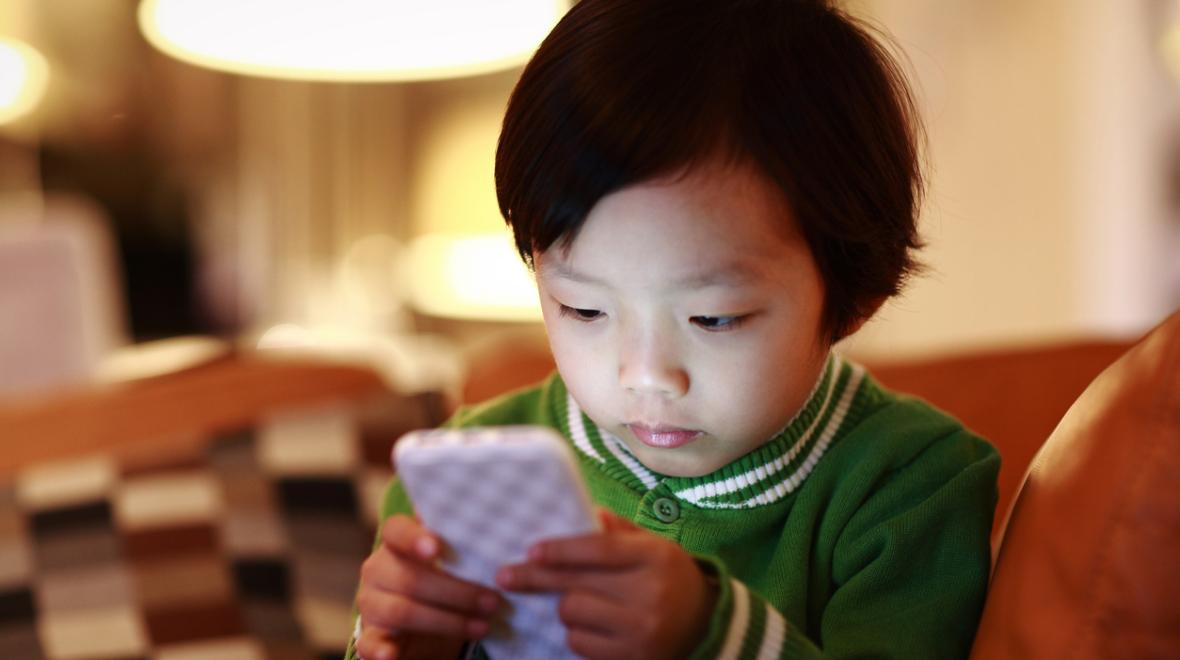 young child is captivated by a cell phone screen