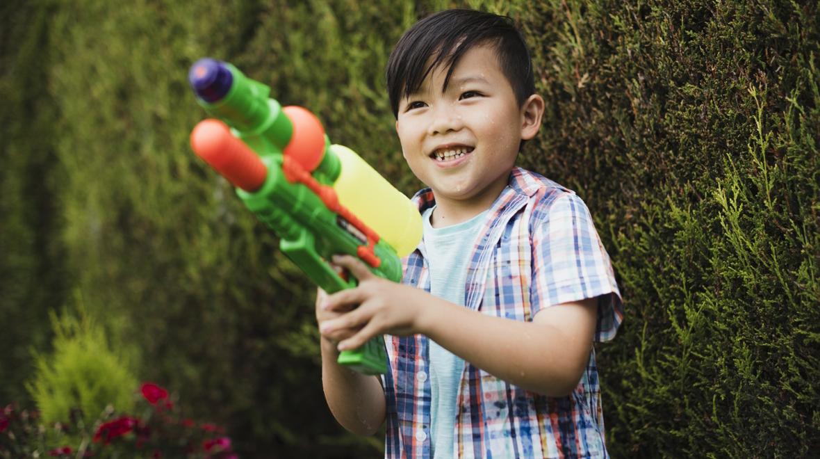 Boy with squirt gun ready for a fun outdoor messy art project