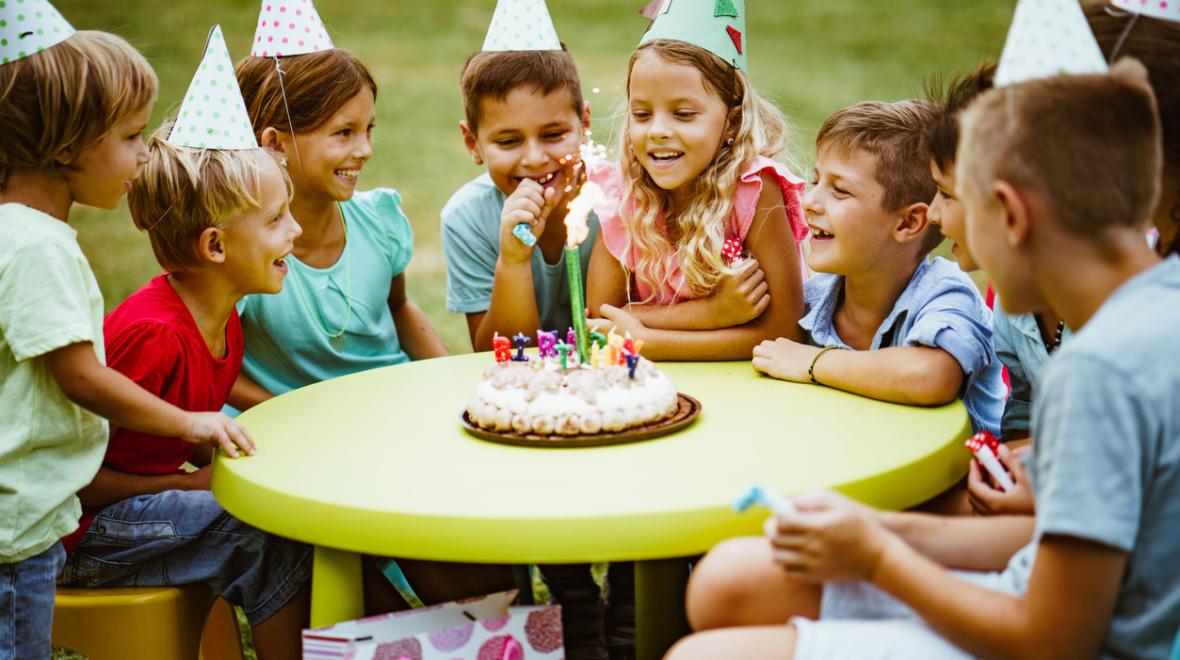 children gather around a cake to celebrate a birthday