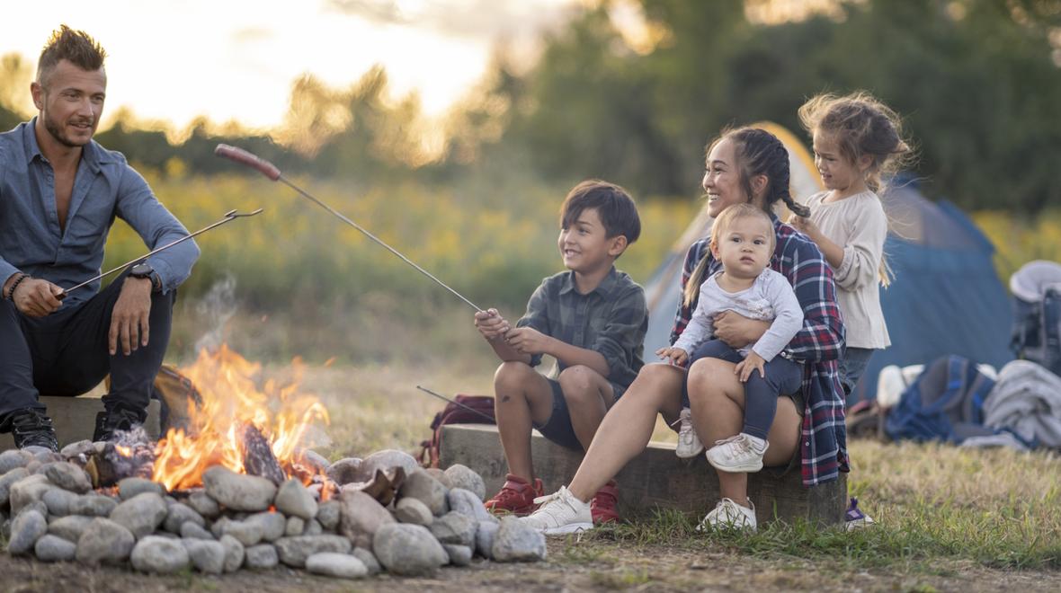 family camping with young children and sitting around a camp fire 