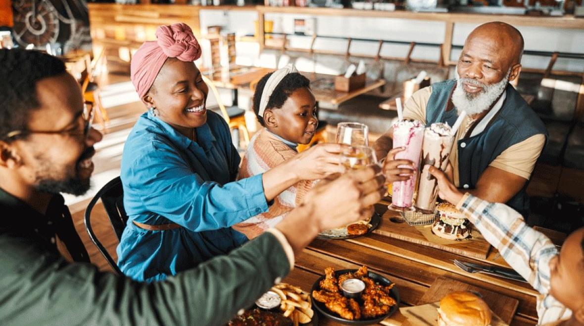 A family sitting at a kid-friendly brewery in Seattle, toasting with their drinks