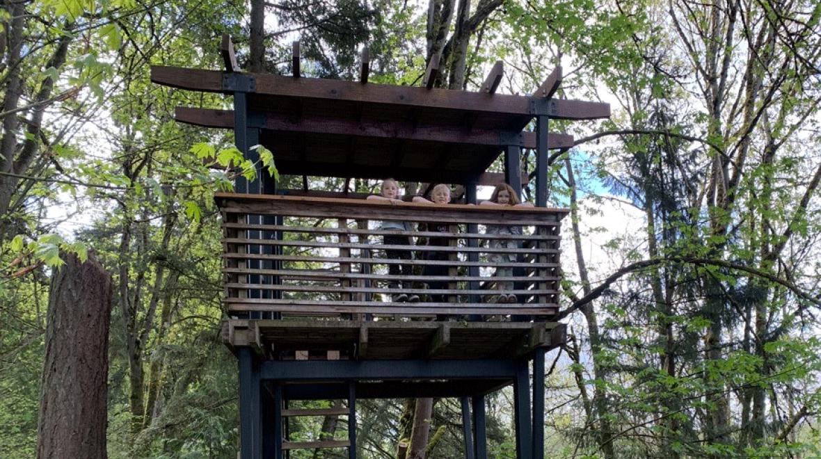 Three kids look out from the tree house tower at Mercer Slough Environmental Education Center near Seattle