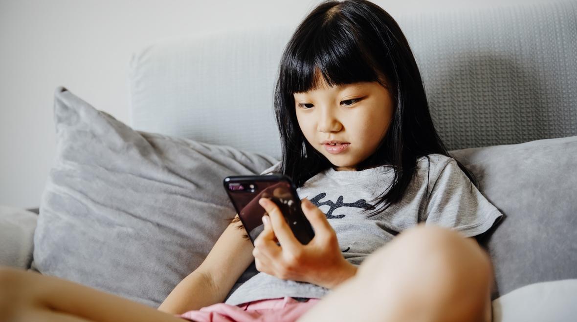 young girl looking at social media on her phone might be part of  The Anxious Generation