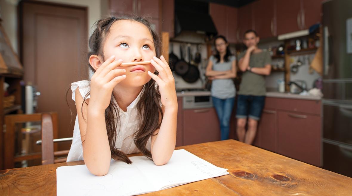 Young girl sitting at a table with homework