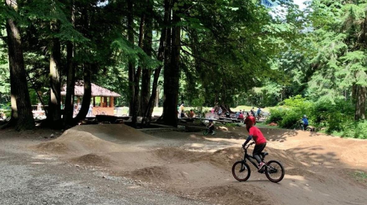 Kid rides bike on the pump track at Duthie Hill Mountain Bike Park near Seattle