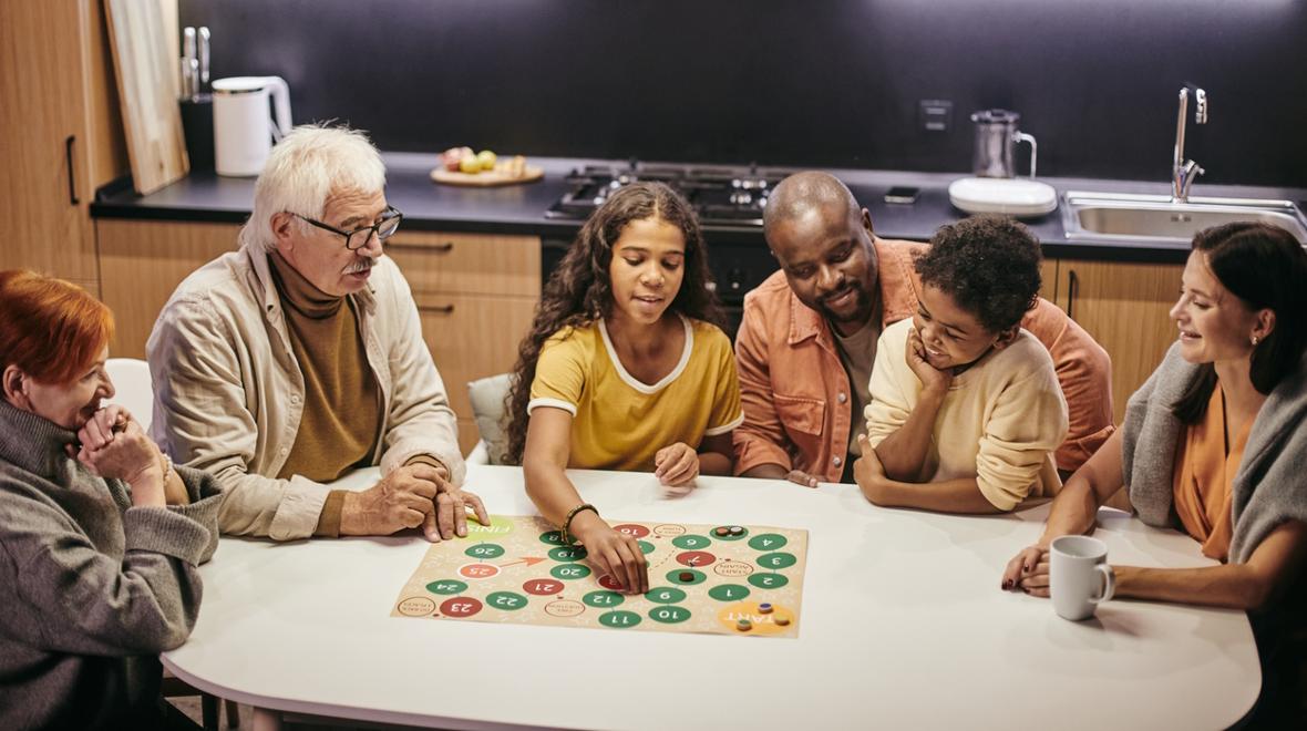 Family sitting around a table having fun at family game night