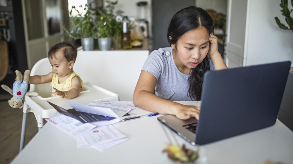 overwhelmed young mom trying to work from home while caring for a baby