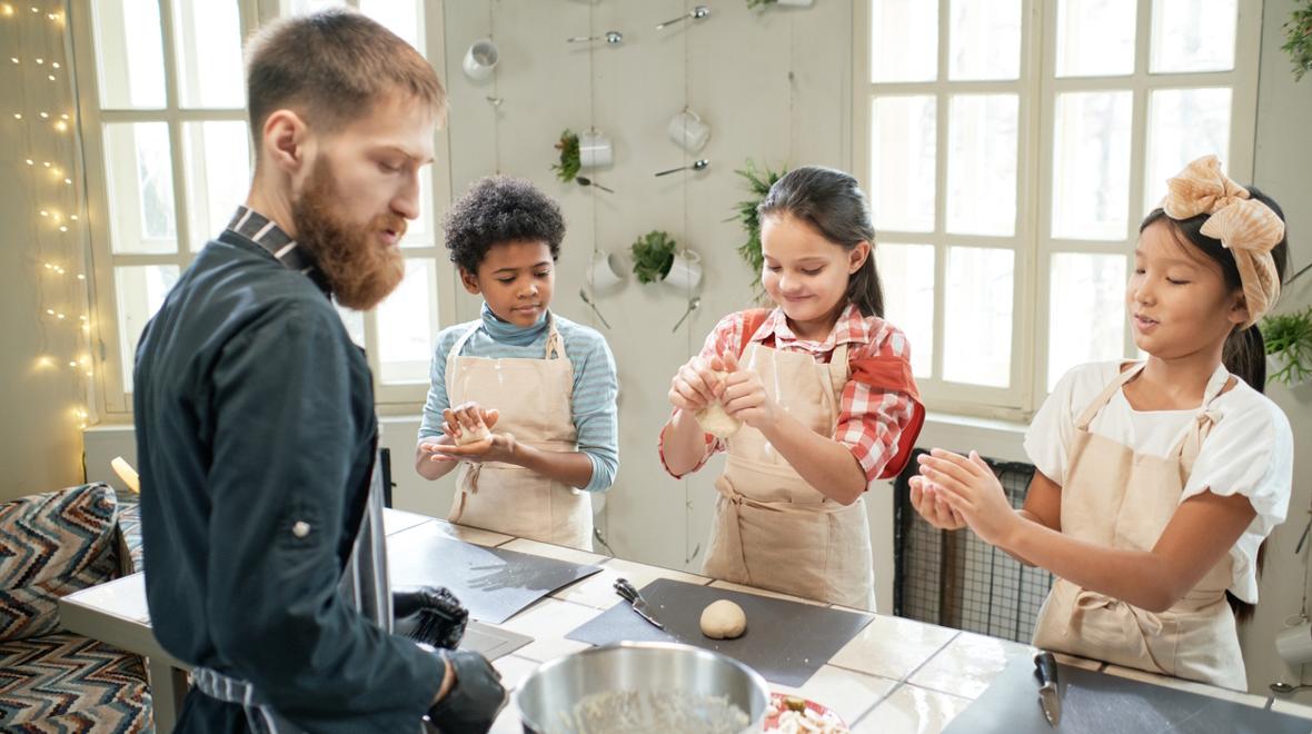 Three kids at a cooking class rolling handfuls of dough, an experience Christmas gift