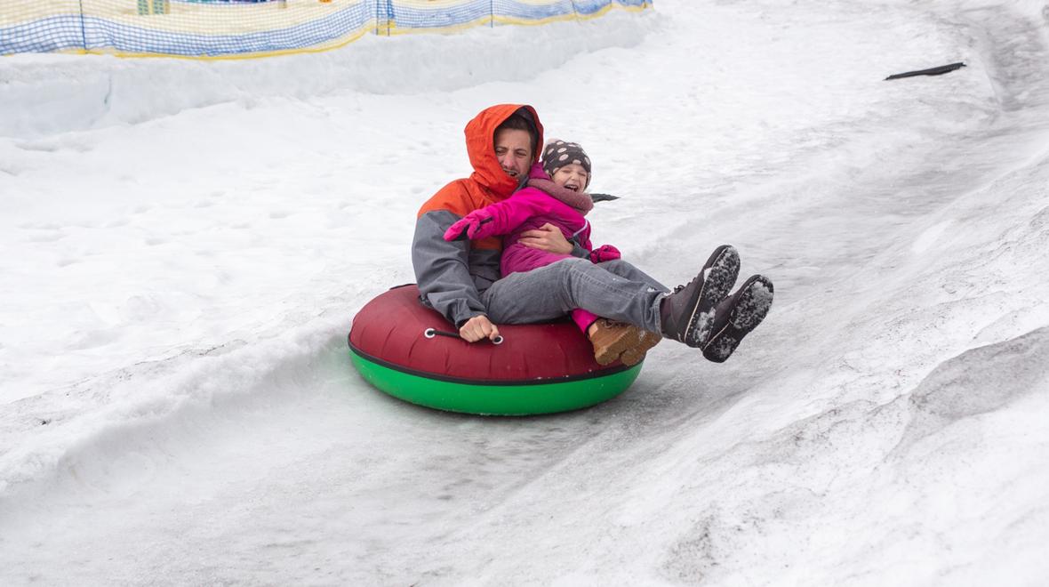 Dad and kid in a snow tube having winter fun near Seattle