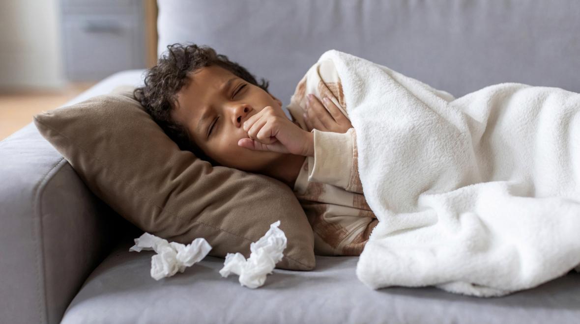 Boy resting on the couch home sick from school