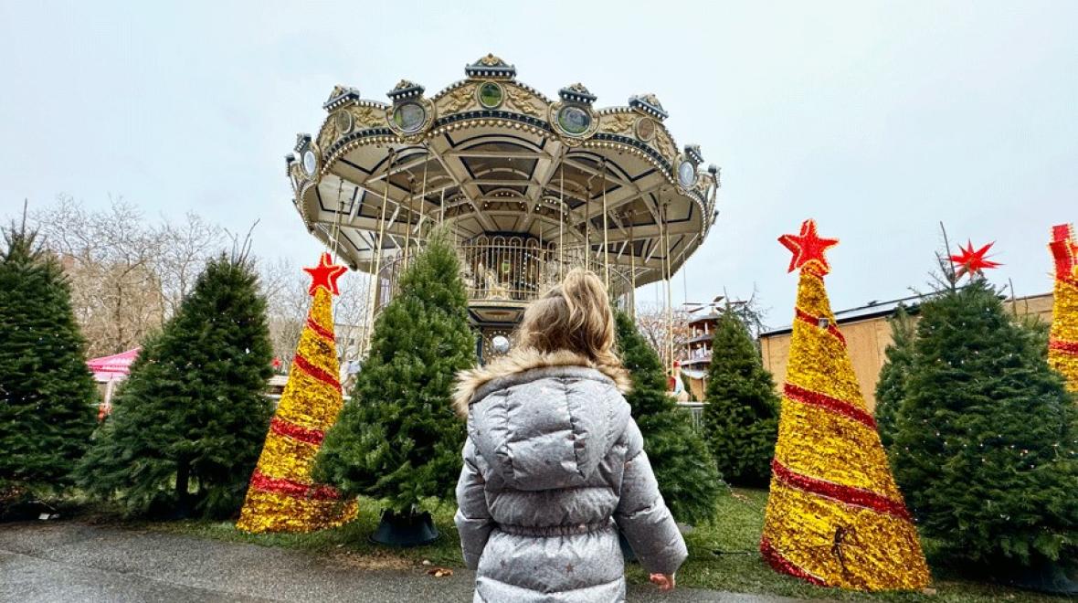 Young girl looking at double-decker Christmas carousel at Seattle Christmas Market