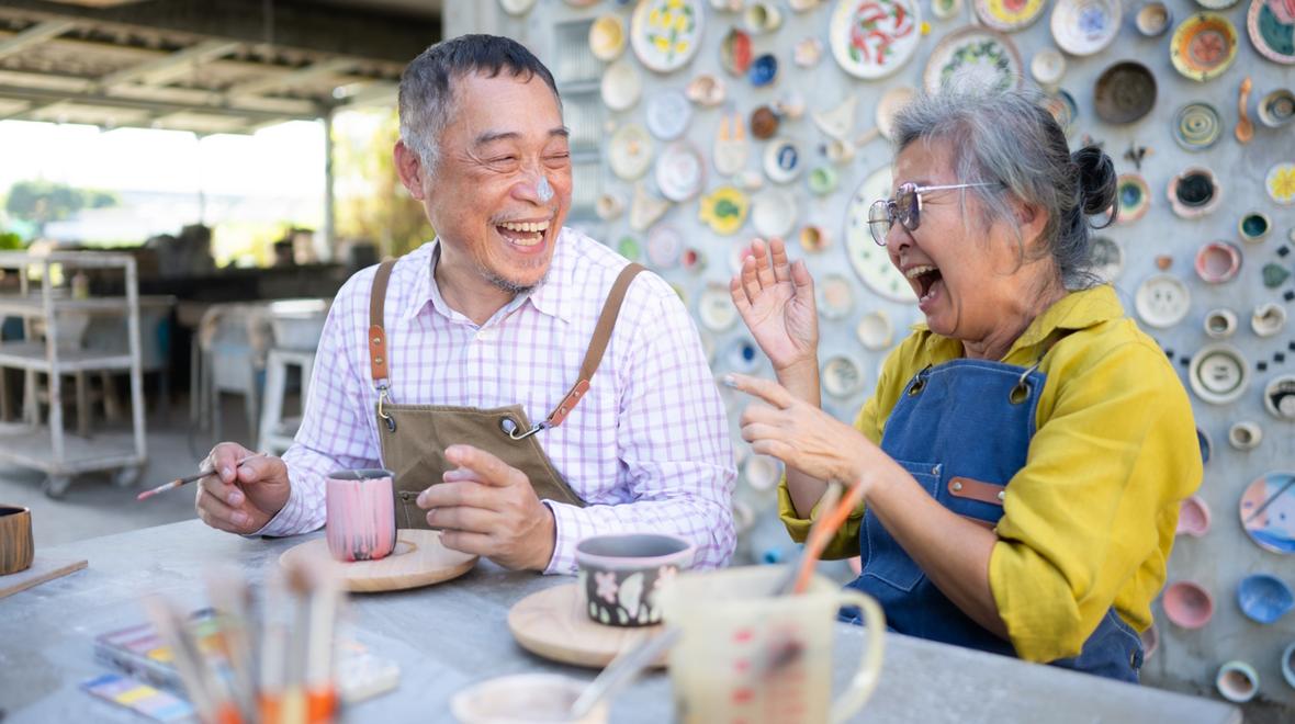 Couple laughing and making pottery together