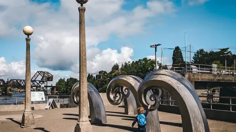 Young kids play by the wave sculptures at Seattle's Ballard Locks among great play destinations for toddlers and preschools while big kids are in school