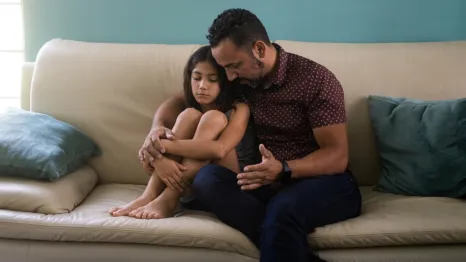 Dad and daughter talking on a couch