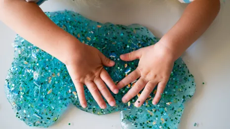 a child pays with DIY glitter slime from a birthday goody bag