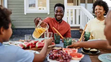 family sitting around a table eating healthy in the summer