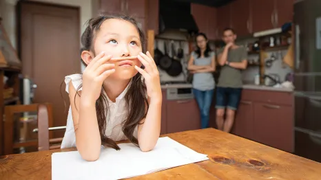 Young girl sitting at a table with homework