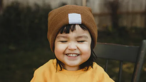 smiling toddler in fall hat and sweater