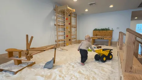 young boy pushing a truck in the lavender-infused sand pit at Wildflower Play Studio in Enumclaw