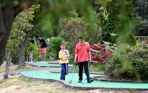 brothers playing mini golf at interbay in Seattle