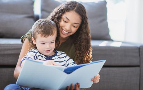 Teenage babysitter reading a book with a child how much to pay your babysitter