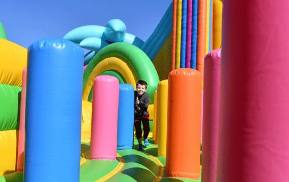 Young boy climbs through colorful inflatables at Bounce The City Seattle