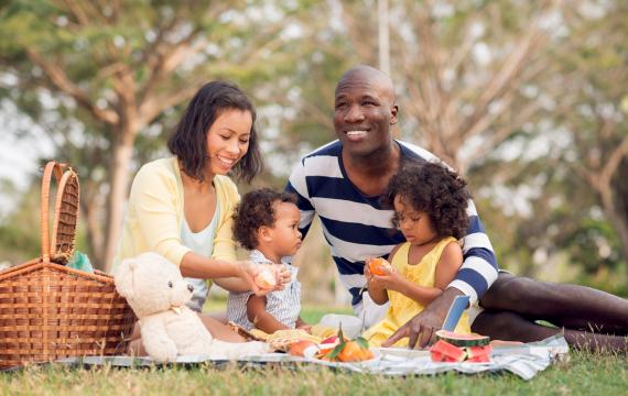 a family with a child enjoys a Pacific Northwest picnic in the park