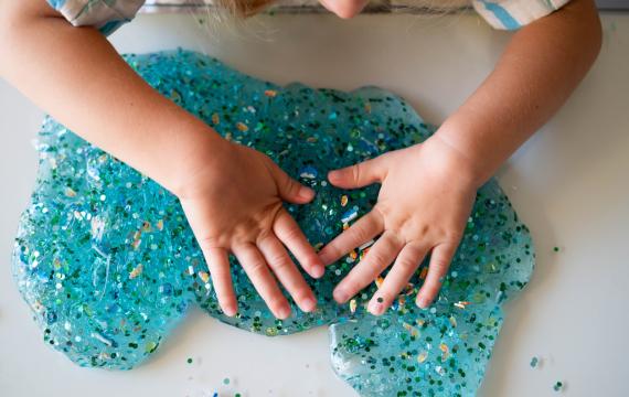 a child pays with DIY glitter slime from a birthday goody bag